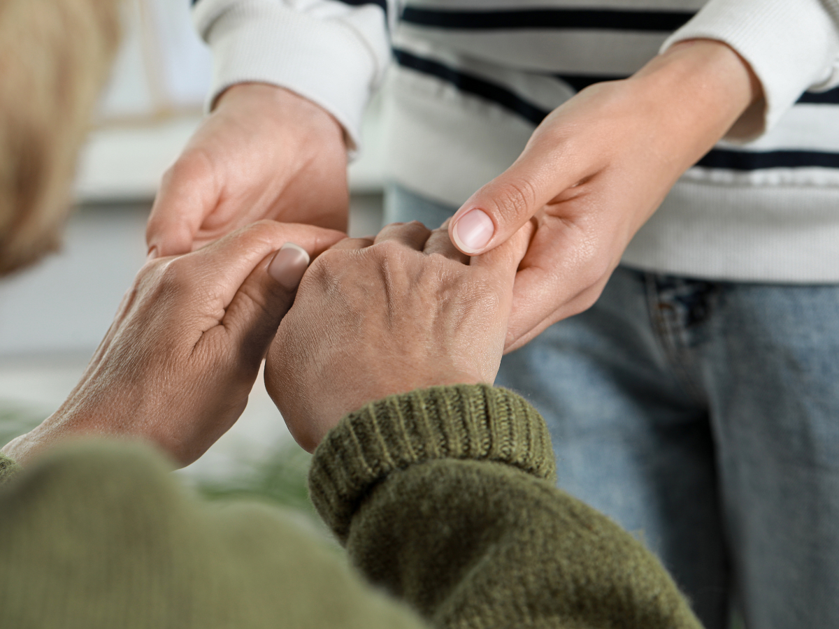caregiver-stress caregiver holding hands of parent