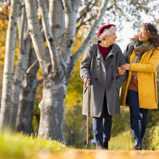Caregiving for mother women walking in yellow jacket while caregiver for mother